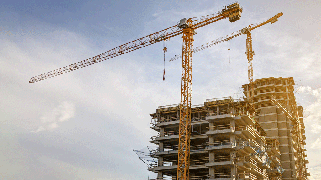 Zone de stockage de matériaux sur chantier avec flèche de grue positionnée au-dessus