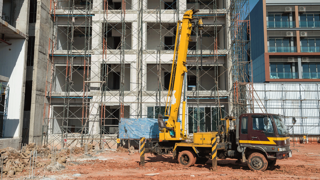 Grue à montage rapide compacte positionnée dans une ruelle étroite de chantier urbain