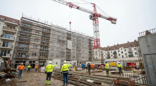 Grue à tour moderne en rotation sur chantier de construction résidentiel urbain
